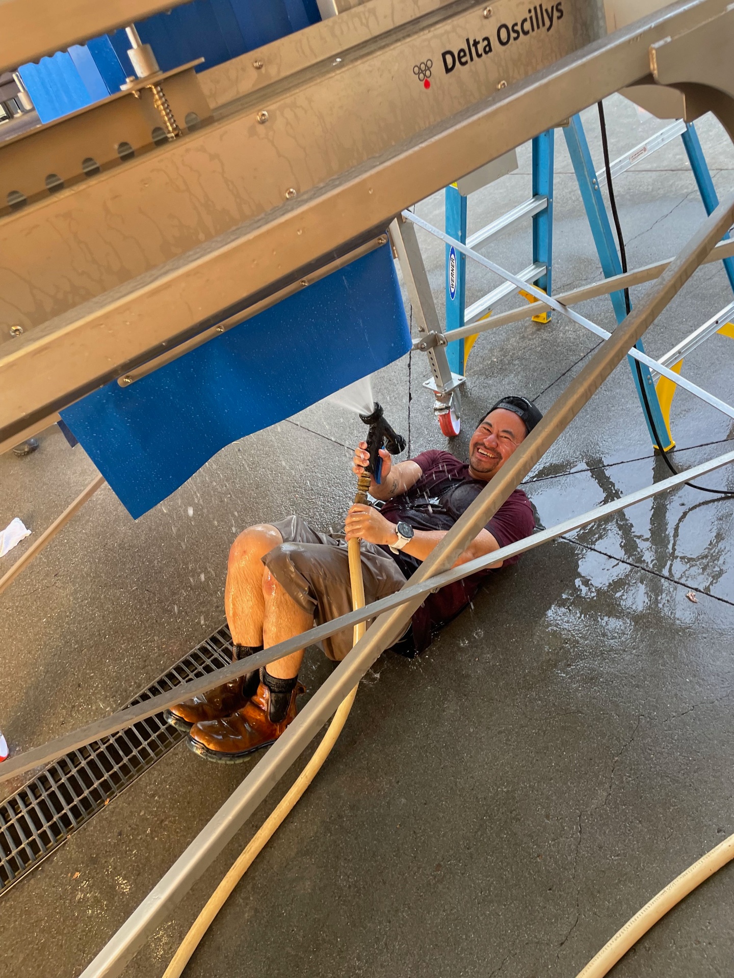 John washing down equipment after a harvest shift — same engine, different uniform.